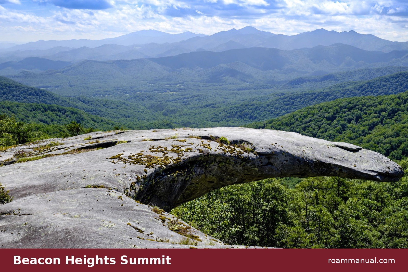 Curved gray rock outcrop at the Beacon Heights summit overlook with layered Blue Ridge mountain ridges stretching into the distance