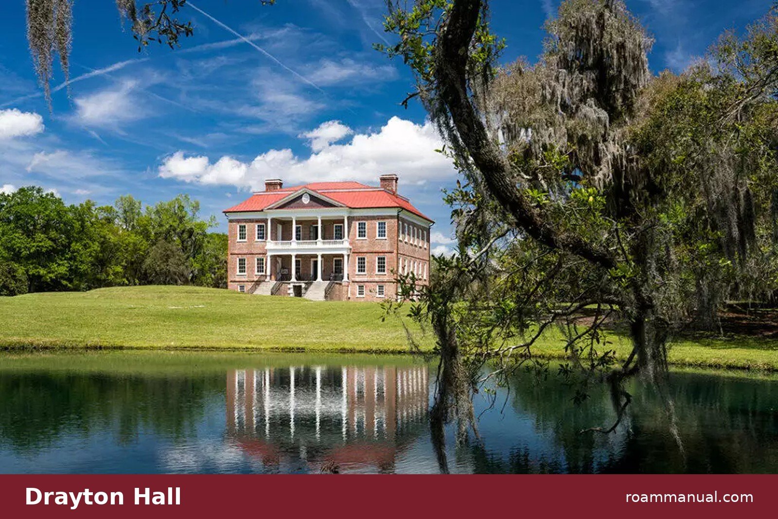 Drayton Hall's brick Palladian house reflected in a pond, framed by a moss-draped oak