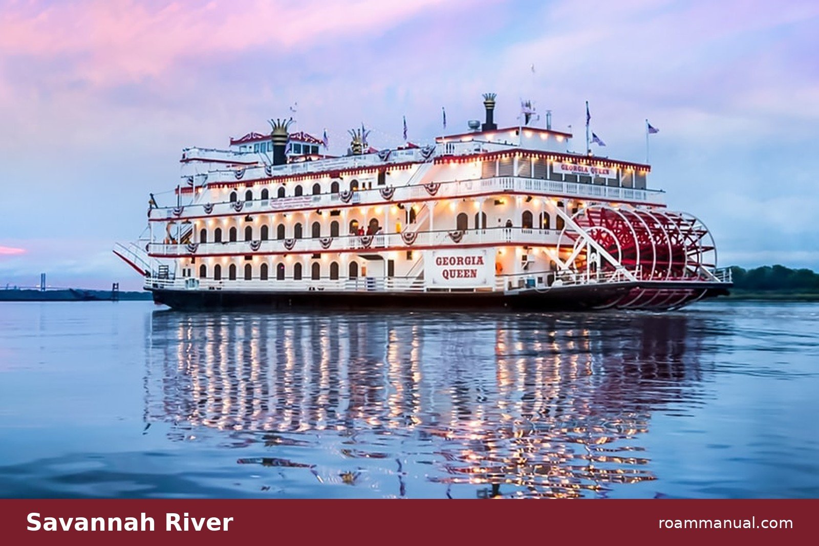 The Georgia Queen riverboat lit up at sunset on the Savannah River during an evening cruise